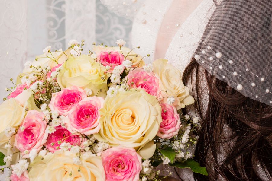 Bride holding a hand-tied bouquet of pink and white flowers
